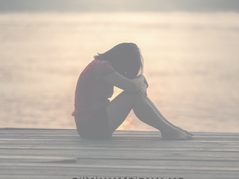 woman on a dock with her head down