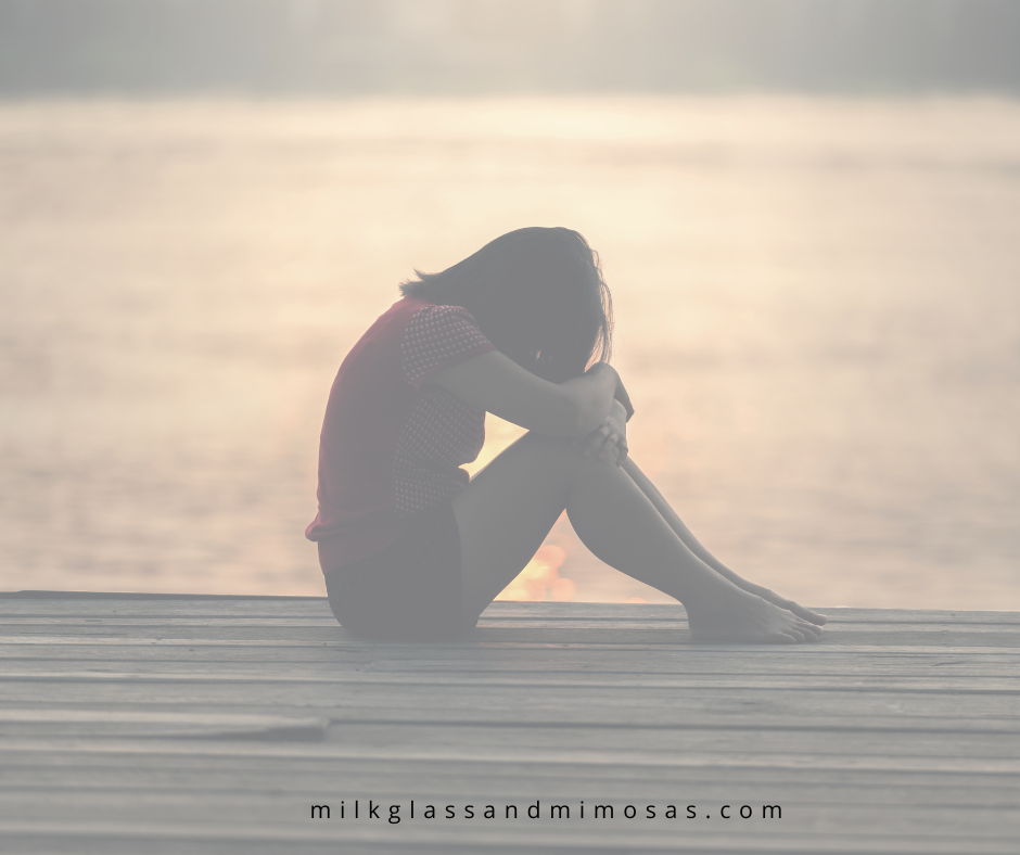 woman on a dock with her head down